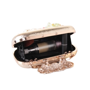 Elegant gold floral clutch bag with ornate handle and spacious interior for makeup