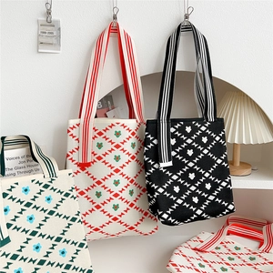 Knit tote bag with geometric floral pattern and striped handles in black and cream