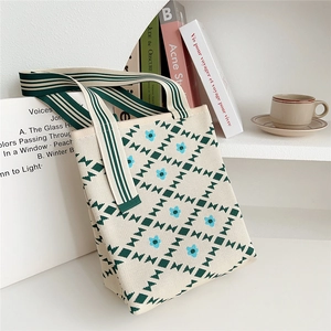 Close-up of knit tote bag with green geometric patterns and soft woven texture details