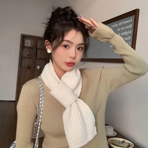 Close-up of white chunky knit scarf showing thick texture and stylish cross-tuck style