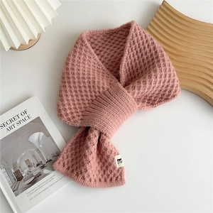 Close-up of pink knit scarf showing honeycomb texture and cross buckle design