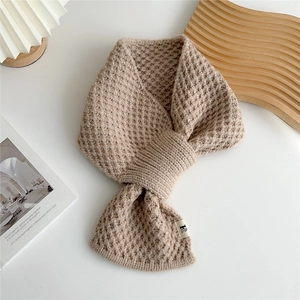 Detail showing the waffle-knit texture and cross-through hole design of this beige winter scarf