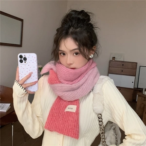 Close-up of thick knit gradient pink scarf with a soft fluffy texture and brand label