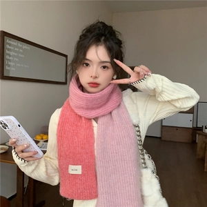 Detail of soft knit scarf with brand label and fluffy pink-orange gradient texture