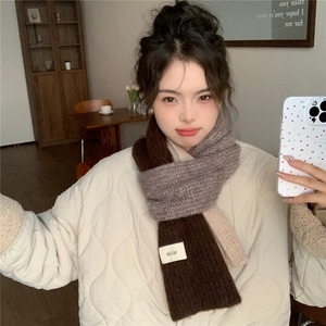 Close-up of tricolor chunky knit scarf showing beige, gray, and brown color block texture