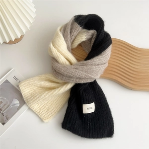 Close-up of tricolor thick knit scarf with cream grey and black textured blocks