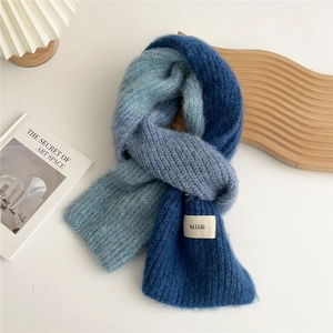 Detail shot of the chunky blue gradient knit scarf with a textured fabric and woven label