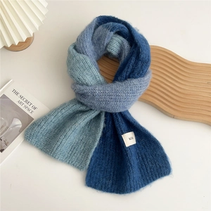 Detailed macro view of the fluffy mohair texture and hilli logo on gradient blue scarf