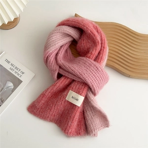 Detailed macro view of soft gradient knit scarf with white hilldi fabric brand label