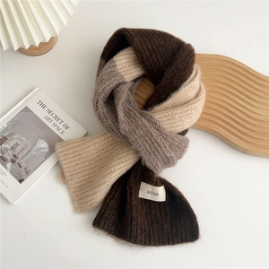 Detail of soft three-color knit scarf with premium texture and woven hilldi brand label