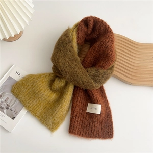 Detail of soft knit scarf with yellow, olive, and brick red color blocking design