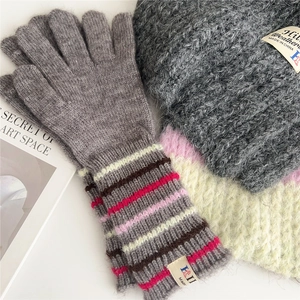 Winter knitted grey gloves and wool hat set with colorful striped wrist cuffs