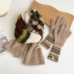 Close-up of thick color-block knitted scarf and matching gloves for winter warmth