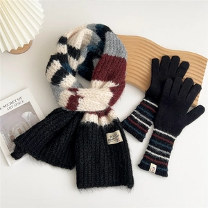 Detailed view of heavy knit scarf and gloves set with retro stripe pattern and soft texture