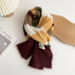 Detailed texture of thick color-block knit scarf with premium stitched brand label