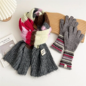 Detailed view of thick multi-color knitted scarf and gray gloves with striped cuffs