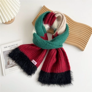 Détail d'une écharpe en maille épaisse color-block avec bordure en peluche et étiquette