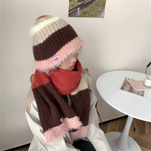 Détail de l'ensemble bonnet et écharpe rayés en maille avec pompons roses en fausse fourrure