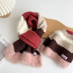 Détail d'un ensemble écharpe et bonnet rayés en maille avec bordure duveteuse