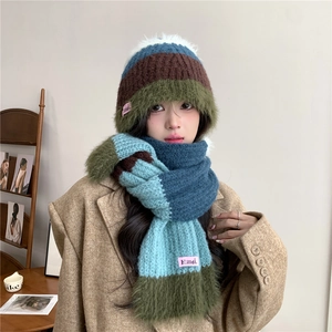 Détail d'un ensemble bonnet et écharpe tricotés à rayures avec pompon blanc et doux