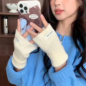 Gros plan détaillé de gants en maille crème sans doigts avec étiquette Jennie Wool
