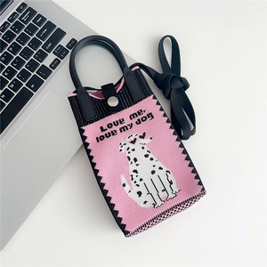 Detail of knitted mini bag featuring pink and black dog pattern with shoulder strap