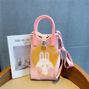 Detailed close-up of a pink knitted mini bag with a cute rabbit jacquard design