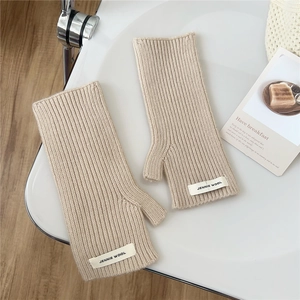 Gros plan de mitaines en tricot beige à rayures verticales avec étiquette décorative
