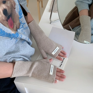Gros plan détaillé des mitaines en tricot côtelé avec une étiquette décorative en tissu