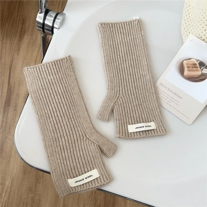 Détail de gants tricotés sans doigts beige avec côtes et étiquette Jennie Wool