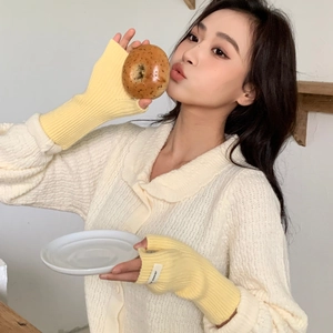 Gros plan de mitaines en tricot jaune montrant la texture et le poignet élastique