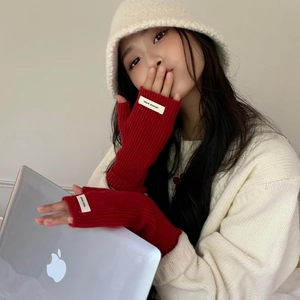Détail de gants rouges en maille côtelée sans doigts avec étiquette Jennie Wool pour hiver