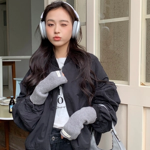 Détail de gants tricotés gris sans doigts avec étiquette tissée blanche sur le poignet