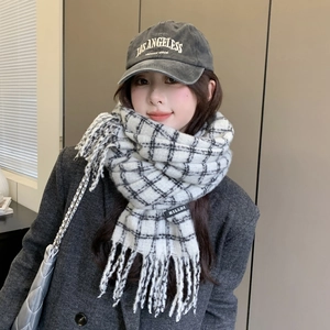 Close-up of black and white checkered scarf with tassels and embroidered baseball cap