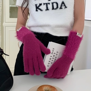 Detail of magenta knitted long gloves with faux fur trim and branded woven label