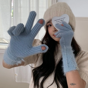 Detail of light blue fingerless knitted gloves with fluffy faux fur cuffs for winter