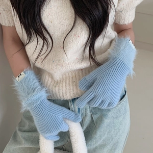 Detail of light blue ribbed knit gloves featuring faux fur trim at the wrist for women