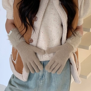 Detail of beige ribbed knit winter gloves with soft faux fur trim around the wrists
