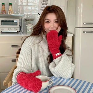Close-up of thick red curly fleece mittens with a woven label on the wrist