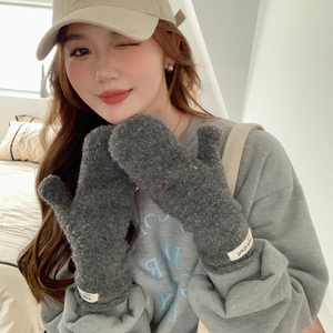 Detail of dark gray plush mittens showing soft fleece texture and brand label