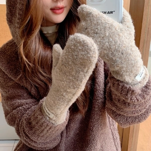 Detail of plush khaki mittens showing thick curly fleece texture and woven wrist label