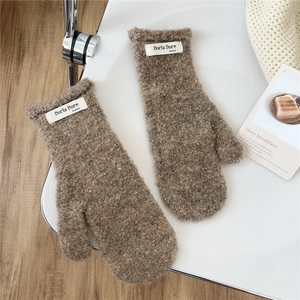 Close-up of thick coffee brown plush mittens with a minimalist white fabric tag detail