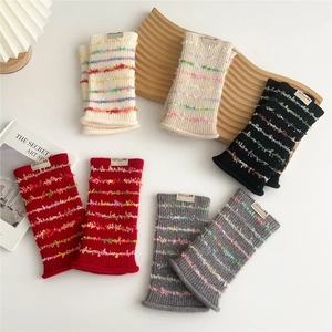 Knitted arm warmers with colorful striped fringe in various colors on white background