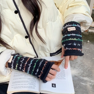 Macro view of black knit fingerless gloves with colorful striped texture and logo tag