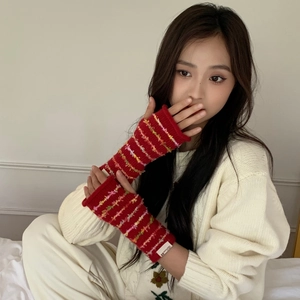 Detail of red knitted arm warmers with colorful stripes and decorative woven label
