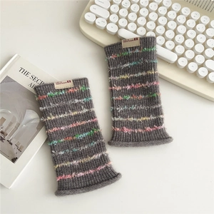 Close-up of grey knitted fingerless gloves with colorful fuzzy stripes and brand tag