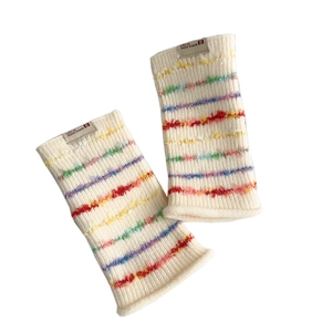 Rainbow striped knit arm warmers in creamy white ribbed wool with colorful fuzzy accents