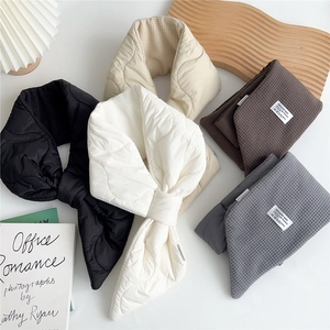Detailed quilted texture and waffle fabric of warm winter scarves in neutral colors