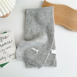 Detailed macro view of 100% wool heather grey knit scarf showing thick ribbed texture