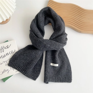 Close-up of 100% wool knit scarf with ribbed edge and dark grey speckled texture